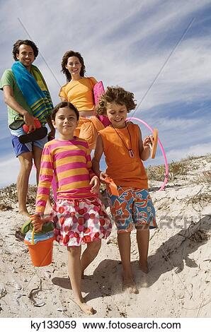 Parents and two children walking on the beach, outdoors View Large Photo Image Stock Photo - Parents and two children walking on the beach, outdoors. Fotosearch