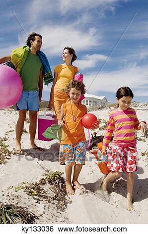 Parents and two children walking on the beach, outdoors View Large Photo Image Stock Photograph - Parents and two children walking on the beach, outdoors. Fotosearch