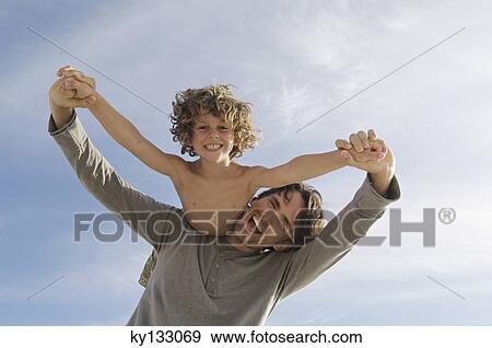 Portrait of a father carrying his son on his back, outdoors View Large Photo Image Stock Photo - Portrait of a father carrying his son on his back, outdoors. Fotosearch