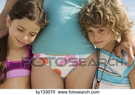 Stock Image - Portrait of two children and their mother, wearing bathsuit, outdoors. Fotosearch