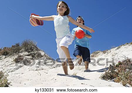 Two children running on the beach, outdoors View Large Photo Image Stock Image - Two children running on the beach, outdoors. Fotosearch