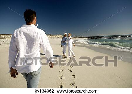 Couple and senior woman walking on beach View Large Photo Image Stock Image - Couple and senior woman walking on beach. Fotosearch