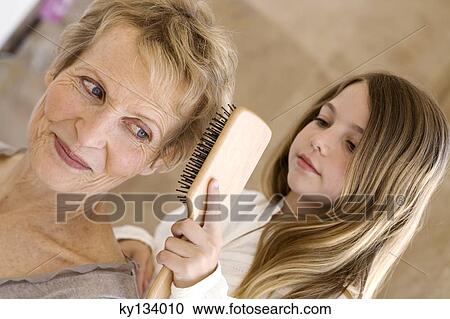Little girl brushing senior woman's hair, indoors View Large Photo Image Stock Image - Little girl brushing senior woman's hair, indoors. Fotosearch