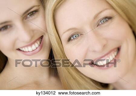 Portrait of two women smiling for the camera, indoors View Large Photo Image Stock Image - Portrait of two women smiling for the camera, indoors. Fotosearch