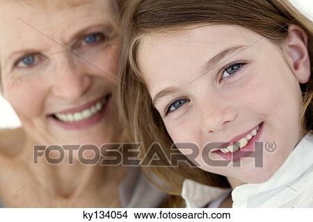 Senior woman and little girl smiling for the camera, indoors View Large Photo Image Picture - Senior woman and little girl smiling for the camera, indoors. Fotosearch