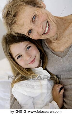 Senior woman and little girl smiling for the camera, indoors View Large Photo Image Stock Image - Senior woman and little girl smiling for the camera, indoors. Fotosearch