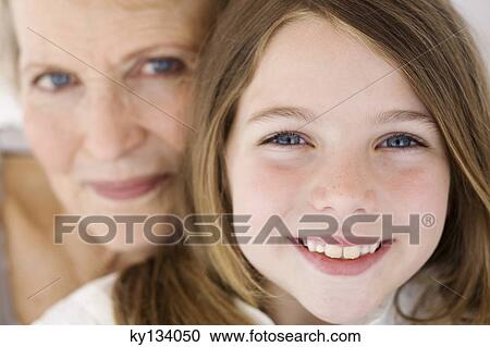 Senior woman and little girl smiling for the camera, indoors View Large Photo Image Stock Image - Senior woman and little girl smiling for the camera, indoors. Fotosearch