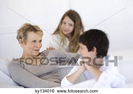 Stock Photograph - Senior woman and two children, indoors. Fotosearch