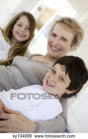 Senior woman and two children smiling for the camera, indoors View Large Photo Image Stock Photograph - Senior woman and two children smiling for the camera, indoors. Fotosearch