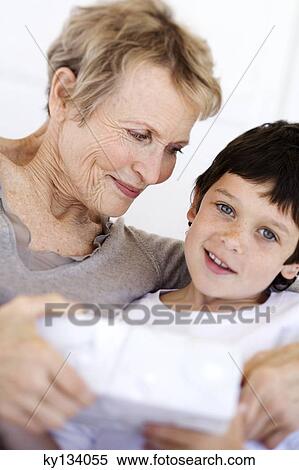 Senior woman giving present to little boy, indoors View Large Photo Image Stock Photography - Senior woman giving present to little boy, indoors. Fotosearch