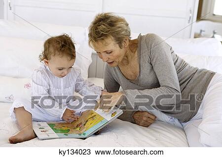 Senior woman reading with little girl, on bed View Large Photo Image Stock Image - Senior woman reading with little girl, on bed. Fotosearch