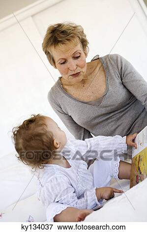 Senior woman reading with little girl, indoors View Large Photo Image Stock Photo - Senior woman reading with little girl, indoors. Fotosearch