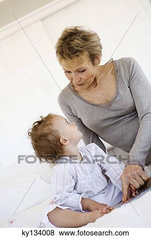 Senior woman with little girl on bed View Large Photo Image Stock Photo - Senior woman with little girl on bed. Fotosearch