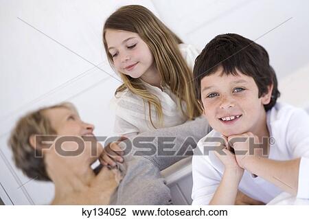 Senior woman with two children, indoors View Large Photo Image Stock Image - Senior woman with two children, indoors. Fotosearch