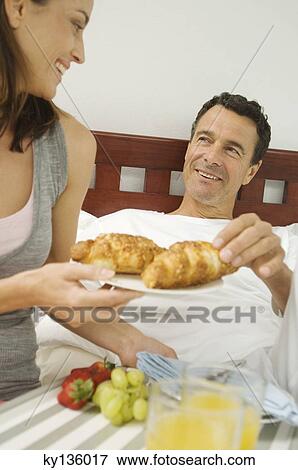 Couple having breakfast in bed, indoors View Large Photo Image Stock Photo - Couple having breakfast in bed, indoors. Fotosearch