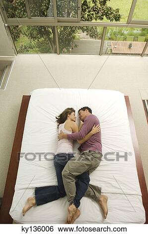 Couple sleeping in a bed, view from above, indoors View Large Photo Image Stock Photograph - Couple sleeping in a bed, view from above, indoors. Fotosearch