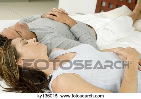 Stock Photography - Couple sleeping on bed, indoors. Fotosearch