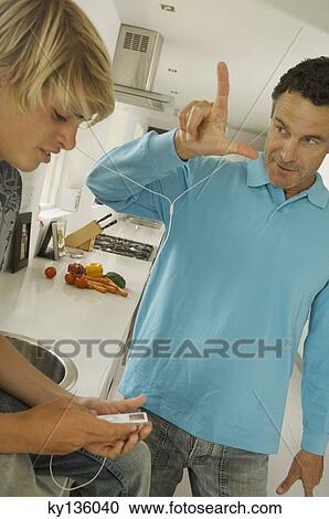 Father and teenager listening to MP3 player, indoors View Large Photo Image Stock Image - Father and teenager listening to MP3 player, indoors. Fotosearch