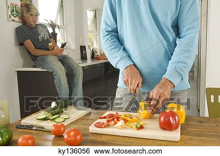 Man cooking, teen sitting in background, indoors View Large Photo Image Stock Photograph - Man cooking, teen sitting in background, indoors. Fotosearch