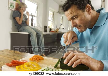 Man cooking, teenager phoning in background, indoors View Large Photo Image Stock Image - Man cooking, teenager phoning in background, indoors. Fotosearch