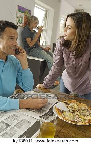 Parents and teenager in living room, pizza on table, indoors View Large Photo Image Stock Image - Parents and teenager in living room, pizza on table, indoors. Fotosearch