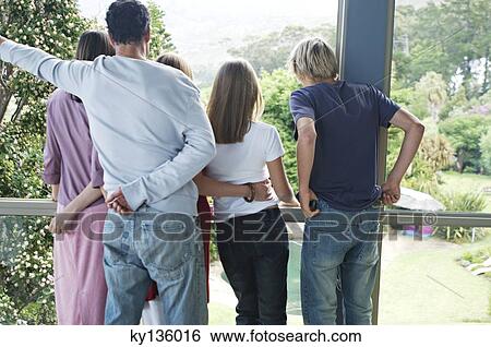 Parents and three teenagers looking through the window, indoors View Large Photo Image Stock Photograph - Parents and three teenagers looking through the window, indoors. Fotosearch