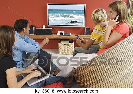 Parents and two teenagers watching television, indoors View Large Photo Image Stock Photo - Parents and two teenagers watching television, indoors. Fotosearch