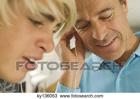 Portrait of a father and his son listening to MP3 player, indoors View Large Photo Image Stock Image - Portrait of a father and his son listening to MP3 player, indoors. Fotosearch