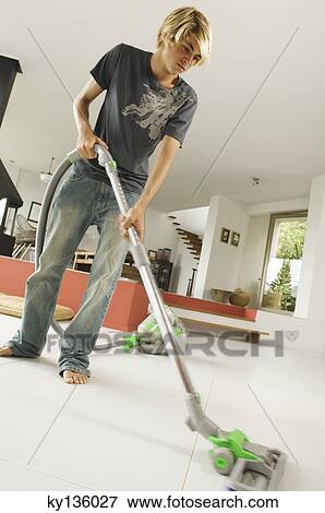 Teenager vacuuming, indoors View Large Photo Image Stock Photo - Teenager vacuuming, indoors. Fotosearch