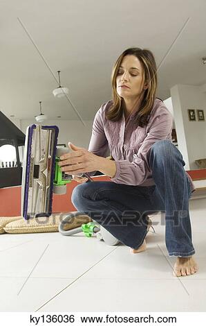 Woman holding a vacuum cleaner, indoors View Large Photo Image Stock Photograph - Woman holding a vacuum cleaner, indoors. Fotosearch