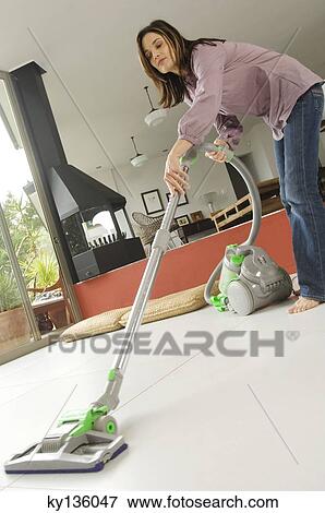 Woman vacuuming, indoors View Large Photo Image Stock Photo - Woman vacuuming, indoors. Fotosearch