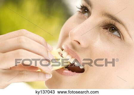 Portrait of a young woman eating a piece of gruyere cheese, outdoors View Large Photo Image Stock Image - Portrait of a young woman eating a piece of gruyere cheese, outdoors. Fotosearch