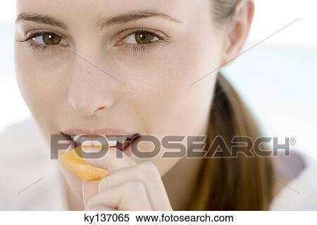 Portrait of a young woman eating a piece of melon, indoors View Large Photo Image Stock Photography - Portrait of a young woman eating a piece of melon, indoors. Fotosearch