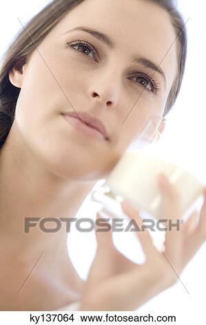Portrait of a young woman holding a milk glass, outdoors View Large Photo Image Picture - Portrait of a young woman holding a milk glass, outdoors. Fotosearch