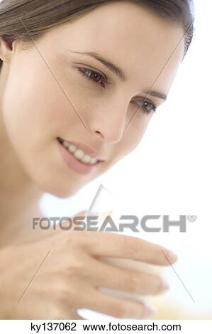 Portrait of a young woman holding a milk glass, indoors View Large Photo Image Stock Image - Portrait of a young woman holding a milk glass, indoors. Fotosearch