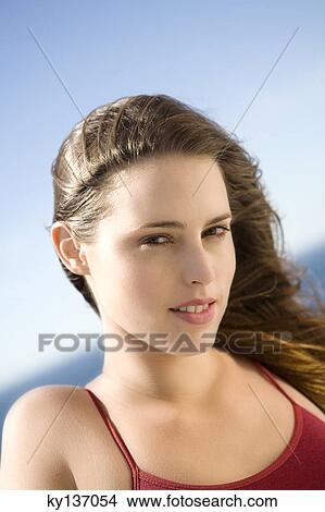 Portrait of a young woman looking at the camera, outdoors View Large Photo Image Picture - Portrait of a young woman looking at the camera, outdoors. Fotosearch
