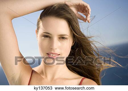Stock Image - Portrait of a young woman looking at the camera, outdoors. Fotosearch