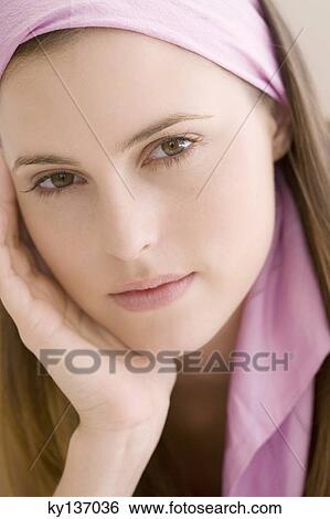 Portrait of a young woman looking at the camera, indoors View Large Photo Image Stock Photograph - Portrait of a young woman looking at the camera, indoors. Fotosearch