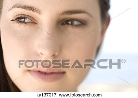 Stock Photo - Portrait of a young woman looking away, indoors. Fotosearch