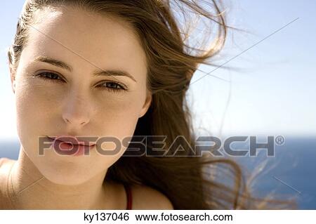 Portrait of a young woman looking for the camera, outdoors View Large Photo Image Stock Photograph - Portrait of a young woman looking for the camera, outdoors. Fotosearch