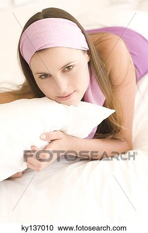 Portrait of a young woman lying, indoors View Large Photo Image Stock Image - Portrait of a young woman lying, indoors. Fotosearch