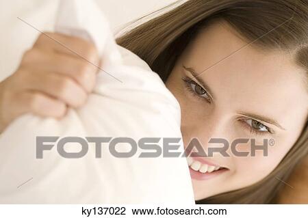 Portrait of a young woman lying, indoors View Large Photo Image Stock Image - Portrait of a young woman lying, indoors. Fotosearch