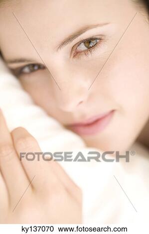 Portrait of a young woman lying, indoors View Large Photo Image Stock Image - Portrait of a young woman lying, indoors. Fotosearch