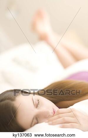 Portrait of a young woman lying, sleeping, indoors View Large Photo Image Stock Image - Portrait of a young woman lying, sleeping, indoors. Fotosearch