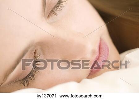 Portrait of a young woman lying, sleeping, indoors View Large Photo Image Stock Image - Portrait of a young woman lying, sleeping, indoors. Fotosearch