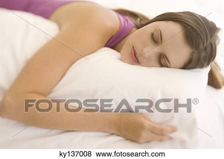 Portrait of a young woman lying, sleeping, indoors View Large Photo Image Stock Photo - Portrait of a young woman lying, sleeping, indoors. Fotosearch