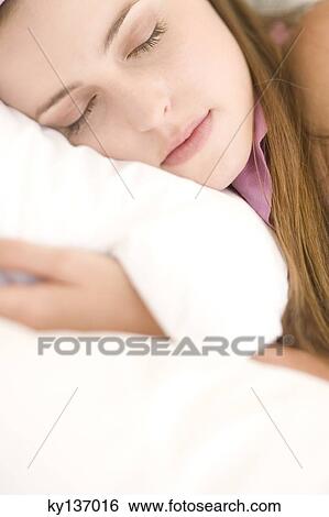 Portrait of a young woman lying, sleeping, indoors View Large Photo Image Stock Photograph - Portrait of a young woman lying, sleeping, indoors. Fotosearch