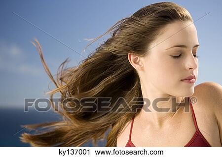 Stock Image - Portrait of a young woman, shut eyes, outdoors. Fotosearch
