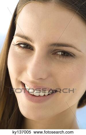 Portrait of a young woman smiling, looking at the camera, indoors View Large Photo Image Stock Photography - Portrait of a young woman smiling, looking at the camera, indoors. Fotosearch