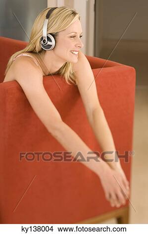 Young woman listening to music with headphones View Large Photo Image Picture - Young woman listening to music with headphones. Fotosearch